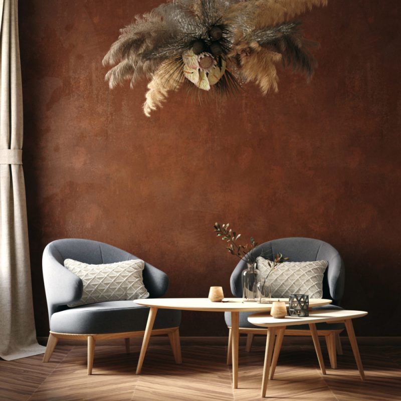Kaffeetisch und Sitze mit Kissen und schöner Deko vor kupferfarbener Wand